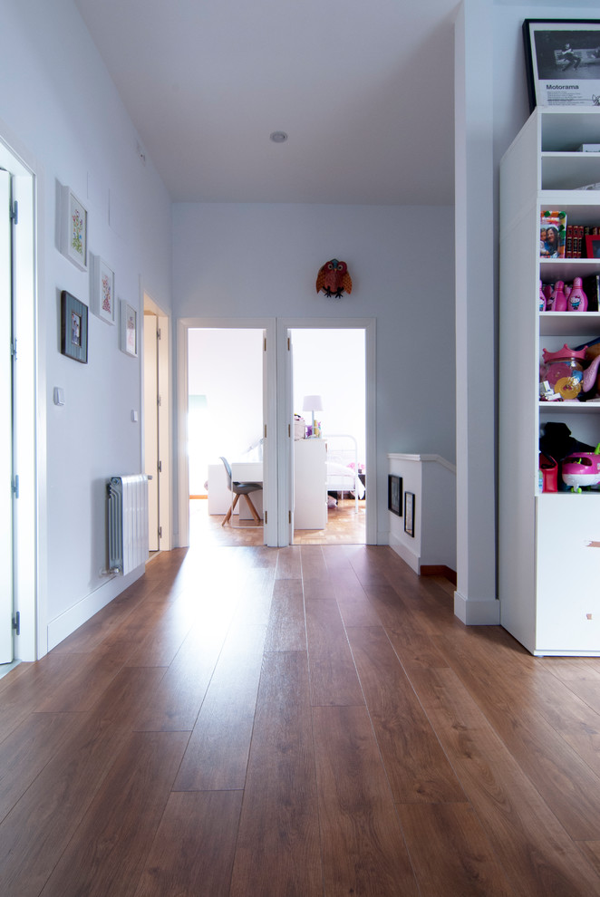 Diseño de dormitorio infantil de 4 a 10 años minimalista de tamaño medio con paredes blancas, suelo de madera clara y suelo marrón