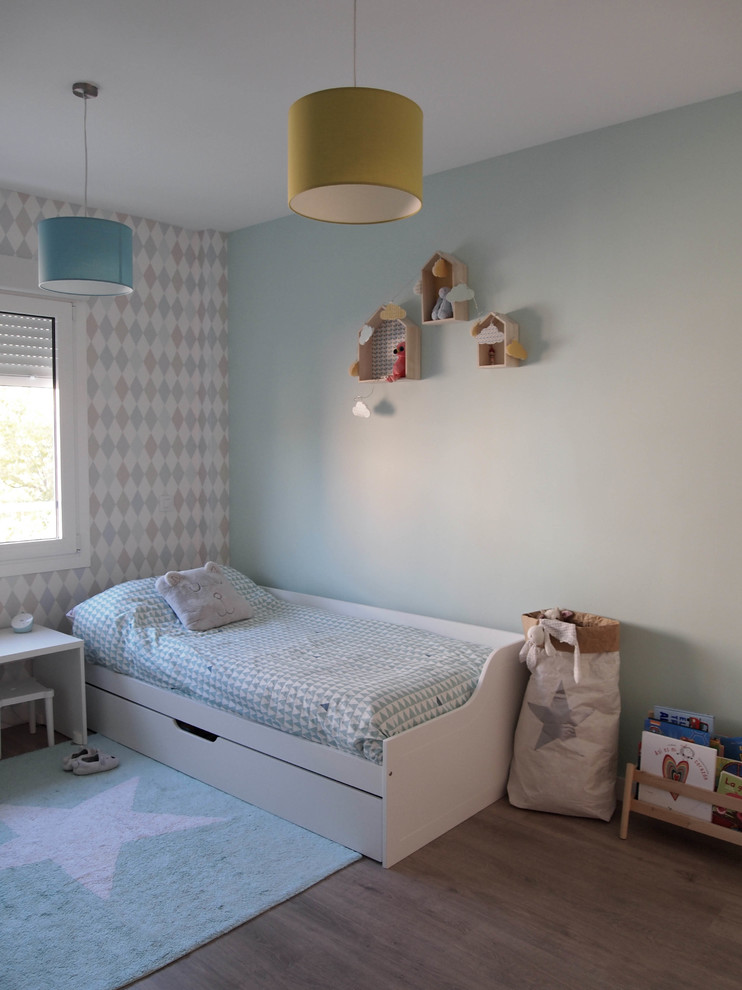 Ejemplo de dormitorio infantil minimalista con paredes azules, suelo laminado y suelo marrón