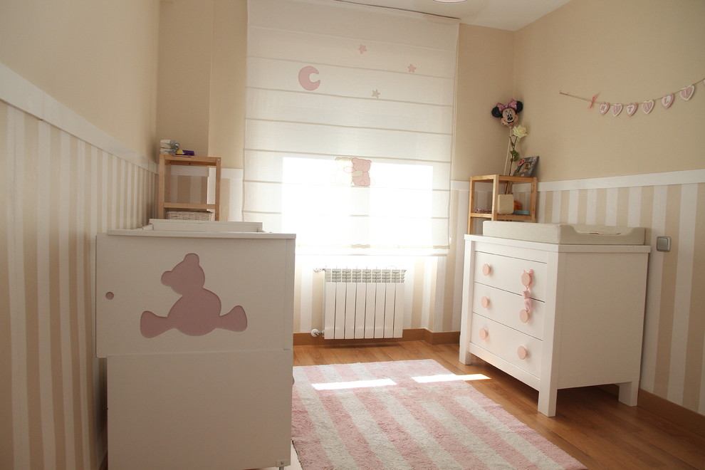 Foto de dormitorio infantil de 1 a 3 años actual de tamaño medio con paredes beige y suelo de madera en tonos medios