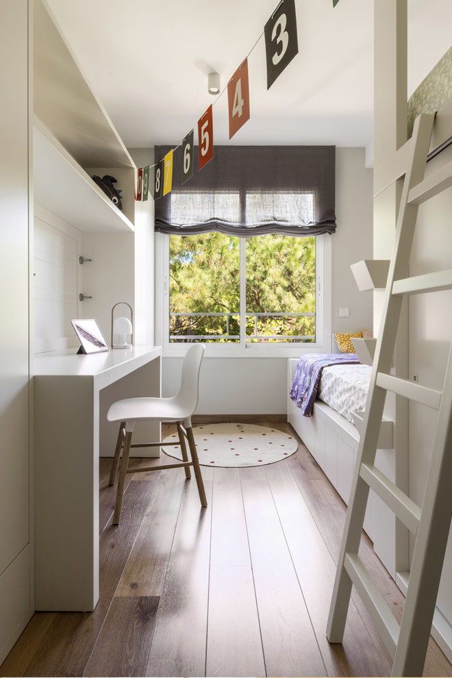 Ejemplo de dormitorio infantil de 4 a 10 años contemporáneo de tamaño medio con paredes blancas, suelo marrón y suelo de madera en tonos medios