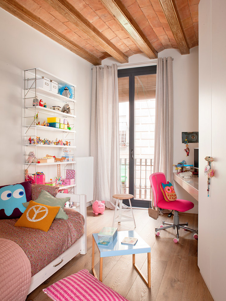 Modelo de habitación de niña de 4 a 10 años contemporánea de tamaño medio con escritorio, paredes beige y suelo de madera en tonos medios
