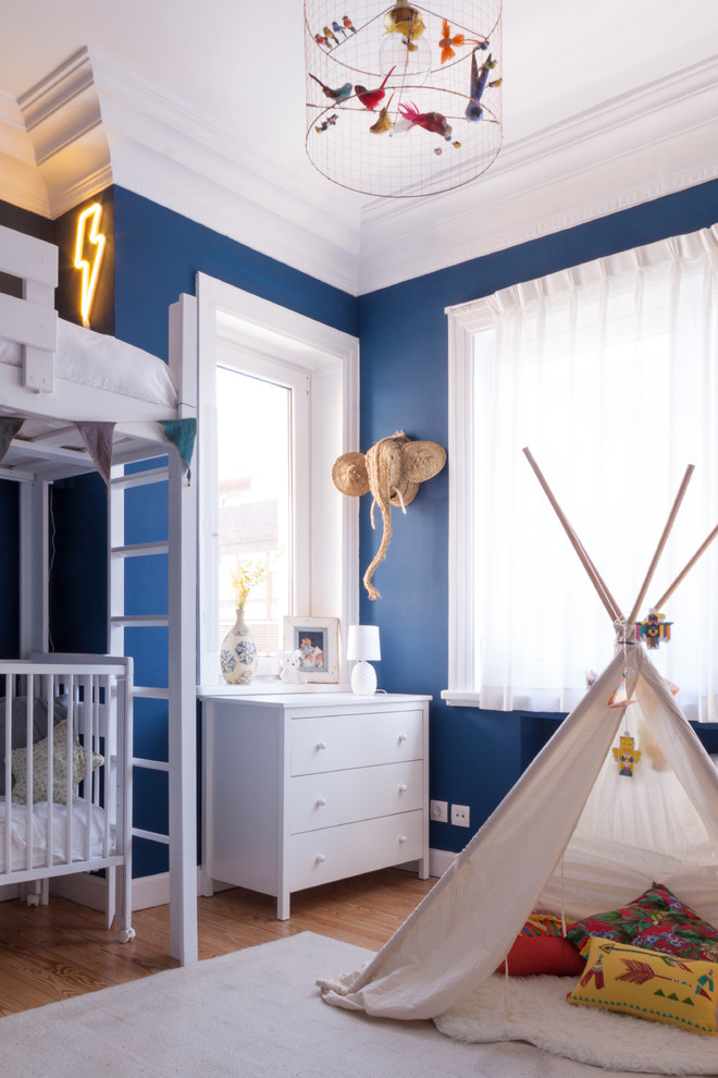 Contemporary kids' bedroom in Other with blue walls, medium hardwood flooring and brown floors.