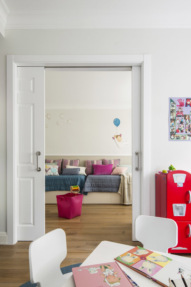 Foto de habitación infantil unisex de 4 a 10 años nórdica grande con escritorio, paredes blancas y suelo de madera en tonos medios