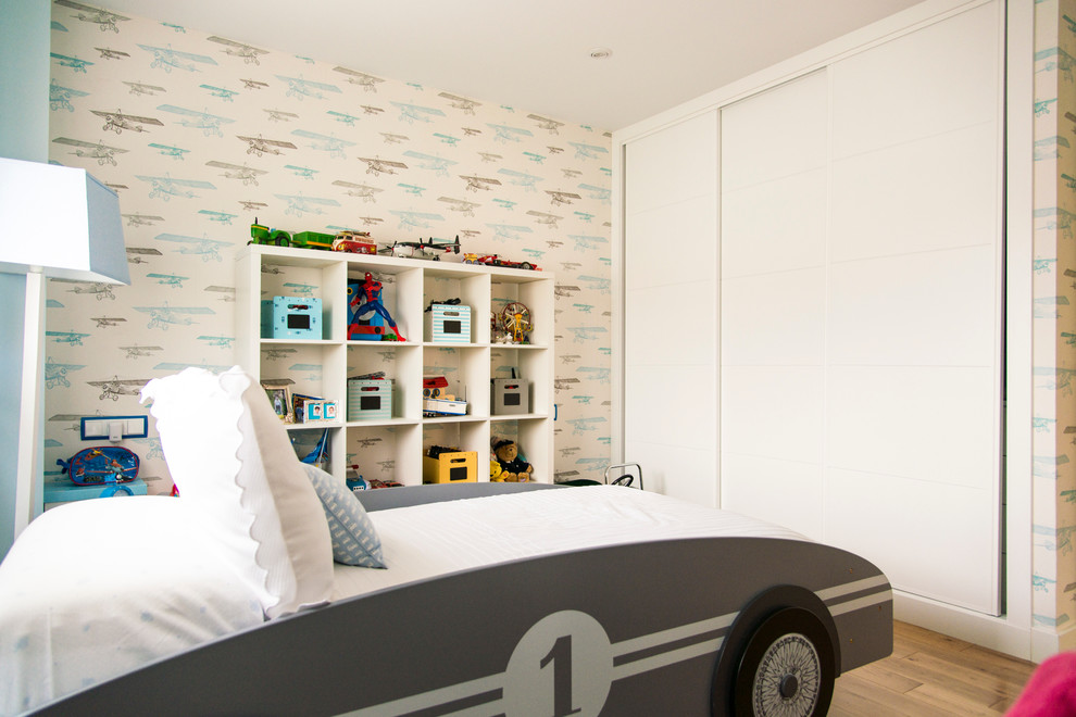 Modelo de dormitorio infantil de 1 a 3 años contemporáneo de tamaño medio con paredes multicolor y suelo de madera en tonos medios