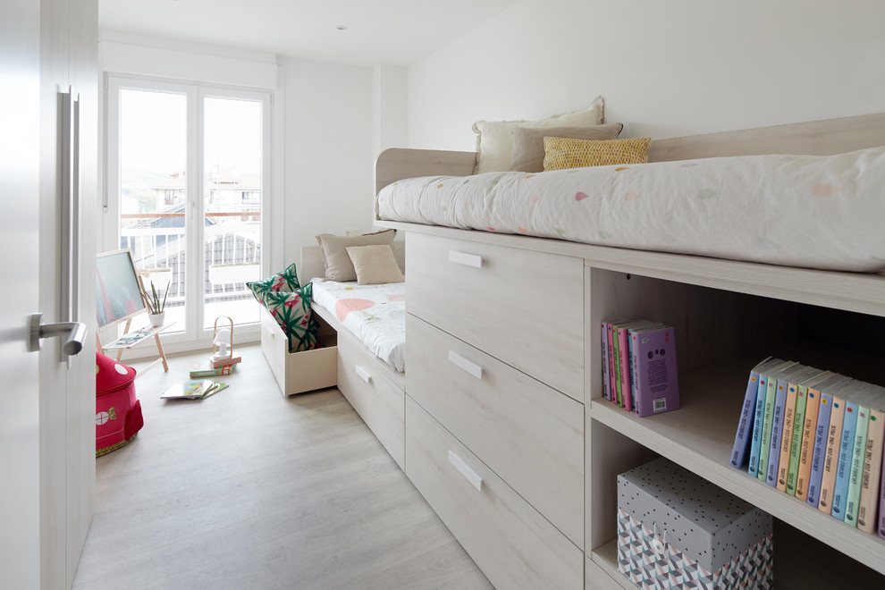 Diseño de dormitorio infantil de 4 a 10 años escandinavo de tamaño medio con paredes blancas, suelo de madera clara y suelo marrón