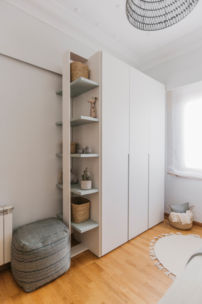 Inspiration for a mid-sized scandinavian gender-neutral medium tone wood floor and wallpaper kids' room remodel in Valencia with beige walls