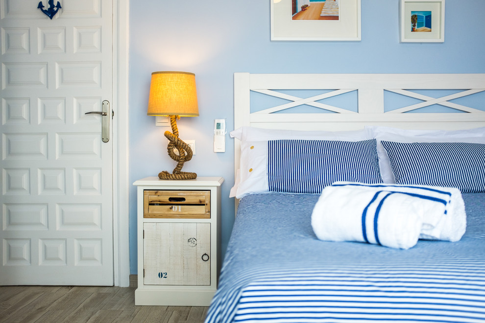 Foto di una camera matrimoniale stile marino di medie dimensioni con pareti blu, parquet chiaro e nessun camino