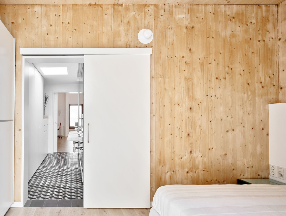 Modelo de dormitorio principal escandinavo de tamaño medio sin chimenea con paredes marrones y suelo de madera clara
