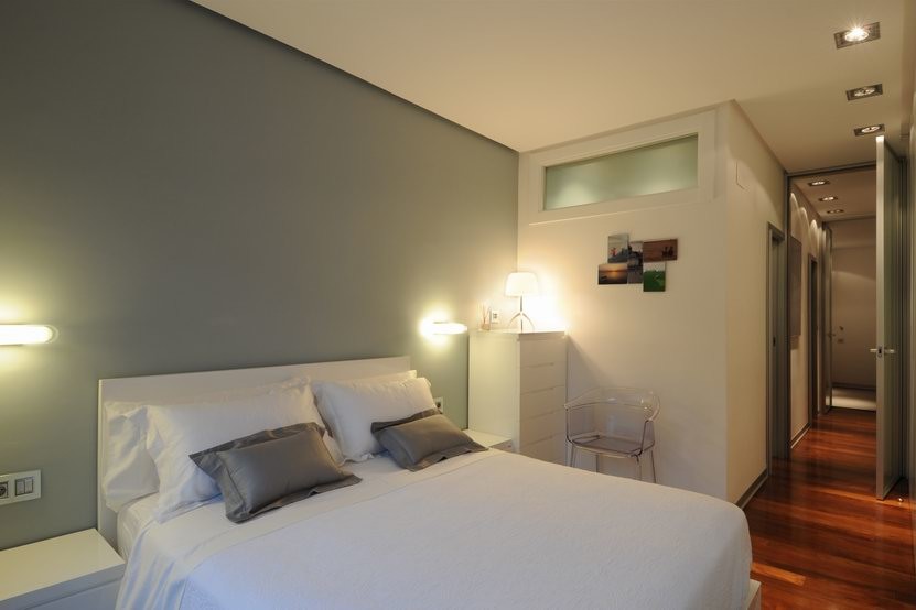 Diseño de dormitorio principal escandinavo de tamaño medio sin chimenea con paredes grises y suelo de madera oscura