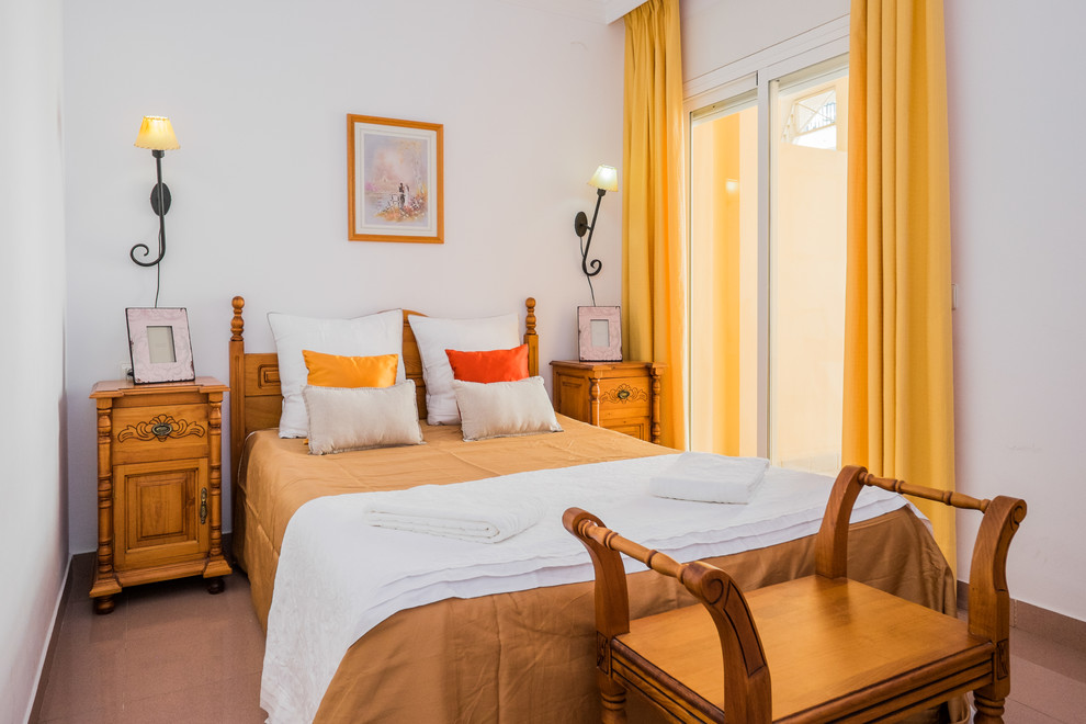 Foto de habitación de invitados mediterránea de tamaño medio sin chimenea con paredes blancas