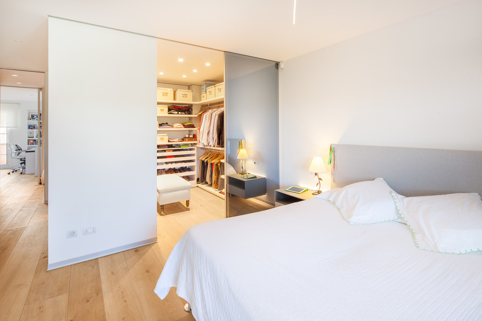 Mittelgroßes Modernes Hauptschlafzimmer ohne Kamin mit hellem Holzboden und weißer Wandfarbe in Madrid