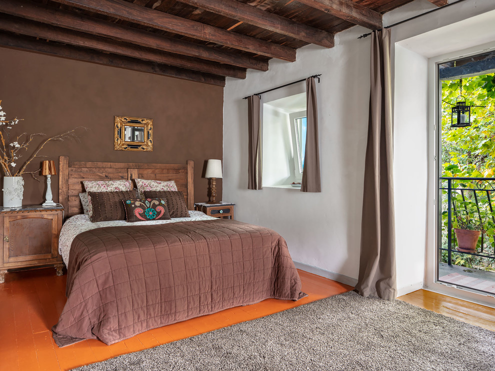 Immagine di un'ampia camera matrimoniale boho chic con pareti bianche, pavimento in legno verniciato, nessun camino e pavimento arancione