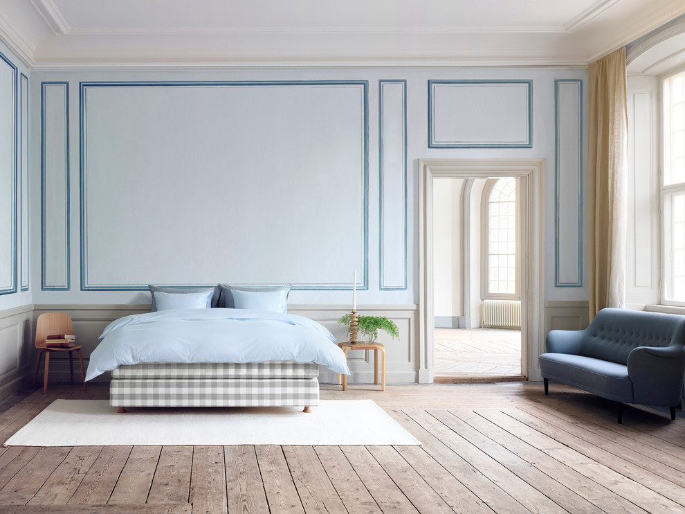 Diseño de habitación de invitados marinera grande con paredes azules y suelo de madera en tonos medios