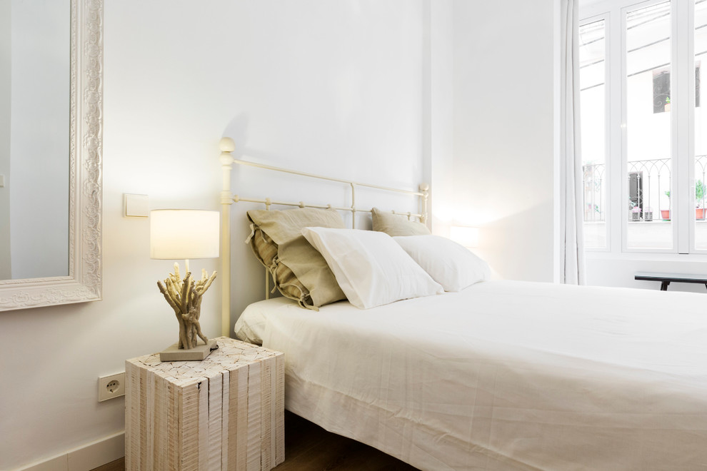 Ejemplo de dormitorio principal nórdico de tamaño medio sin chimenea con paredes blancas y suelo de madera oscura