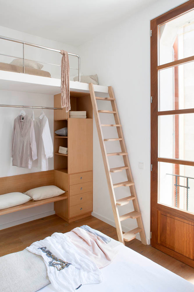 Ejemplo de habitación de invitados nórdica de tamaño medio sin chimenea con paredes blancas y suelo de madera en tonos medios