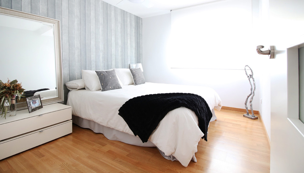 Exemple d'une chambre parentale tendance de taille moyenne avec un mur blanc, un sol en bois brun et aucune cheminée.