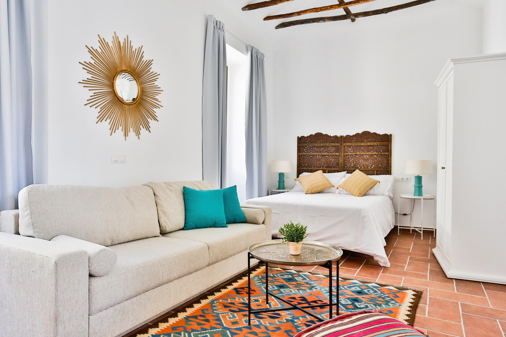 Ejemplo de dormitorio principal mediterráneo de tamaño medio con paredes blancas y suelo de baldosas de terracota