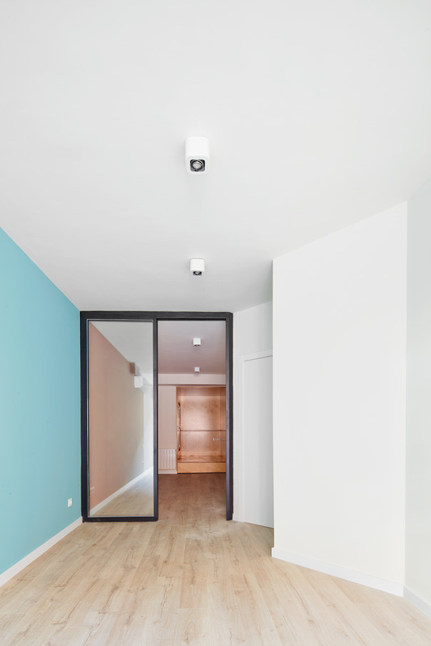 Mittelgroßes Modernes Schlafzimmer im Loft-Style, ohne Kamin mit blauer Wandfarbe und braunem Holzboden in Barcelona