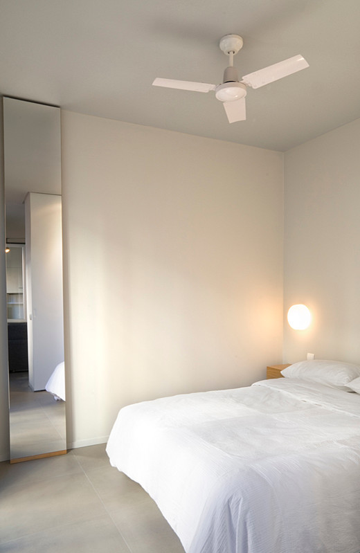Inspiration pour une petite chambre urbaine avec un mur gris, sol en béton ciré et une cheminée standard.