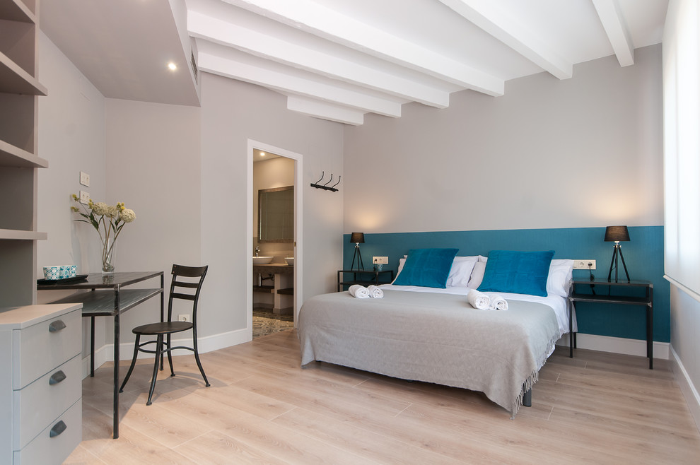 Modelo de dormitorio principal tradicional renovado de tamaño medio sin chimenea con paredes multicolor y suelo de madera clara
