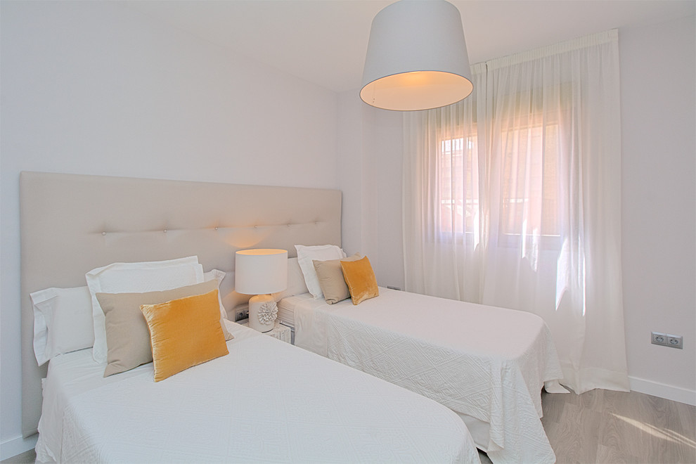 Ejemplo de habitación de invitados mediterránea de tamaño medio sin chimenea con paredes blancas