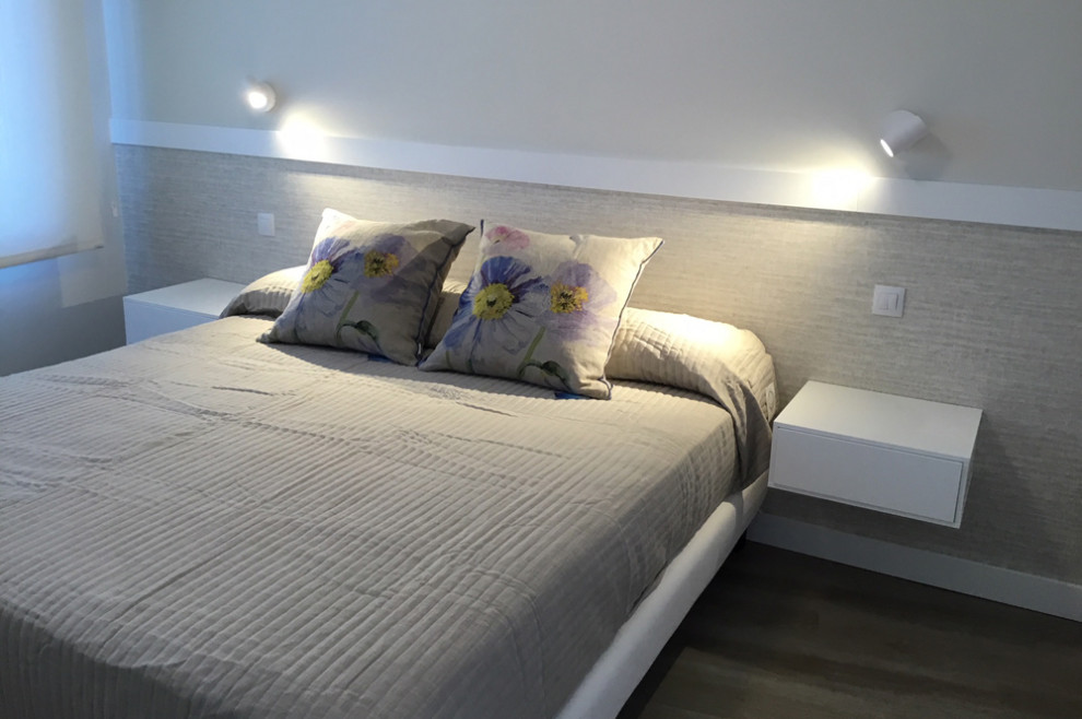 Foto de dormitorio principal contemporáneo pequeño con paredes grises, suelo vinílico y suelo marrón