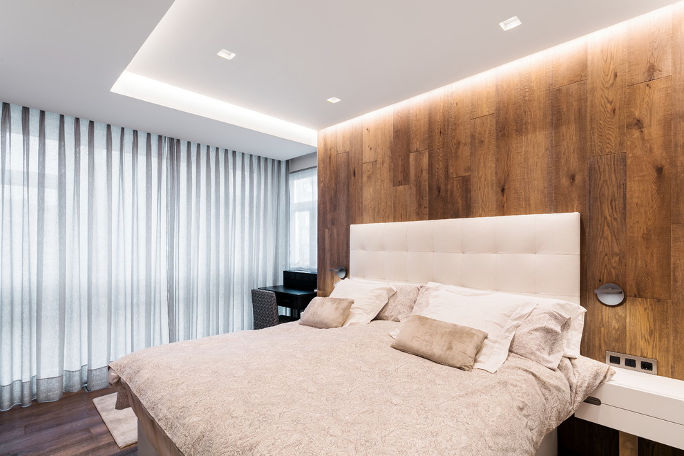 Contemporary master bedroom in Bilbao with dark hardwood flooring.