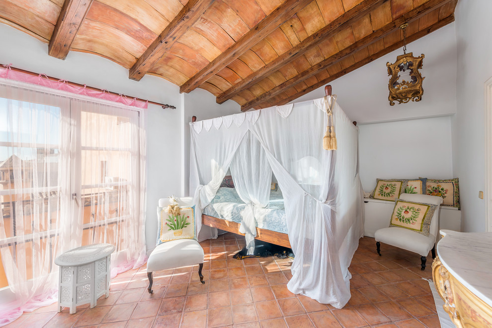 Ejemplo de dormitorio principal mediterráneo de tamaño medio sin chimenea con paredes blancas y suelo de baldosas de terracota