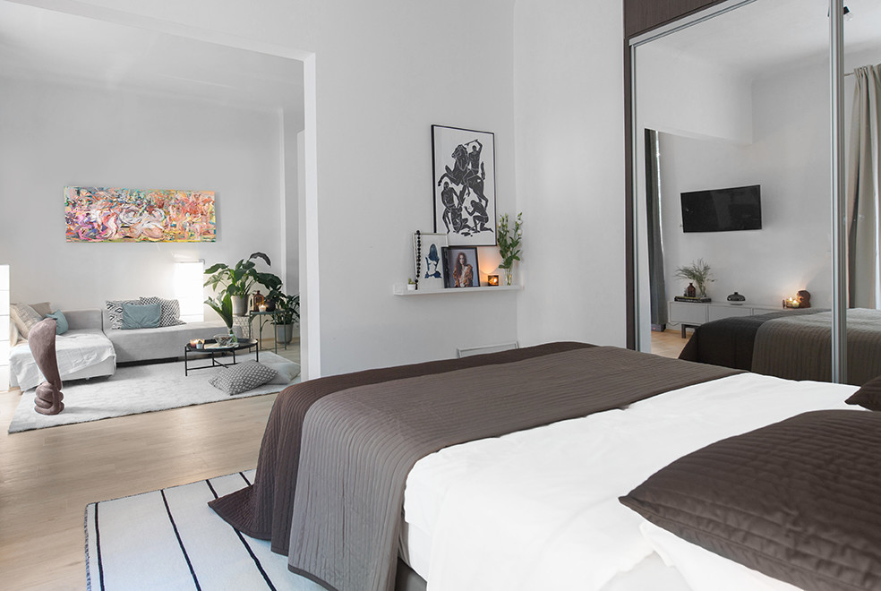 Imagen de dormitorio tipo loft contemporáneo de tamaño medio con paredes blancas, suelo laminado y suelo gris
