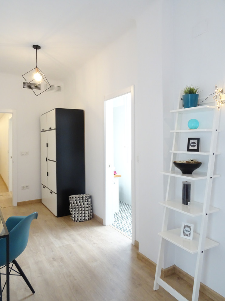 Cette photo montre une chambre parentale scandinave de taille moyenne avec un mur blanc et un sol en bois brun.