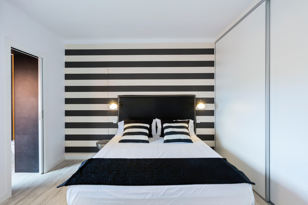 Modelo de dormitorio principal minimalista de tamaño medio sin chimenea con paredes multicolor y suelo de madera clara