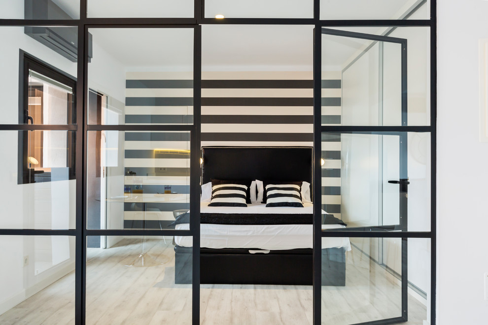 Cette image montre une chambre parentale design de taille moyenne avec un mur multicolore, parquet clair et aucune cheminée.