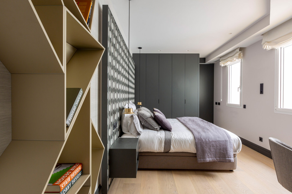 Imagen de dormitorio actual con paredes multicolor, suelo de madera clara, suelo beige y papel pintado