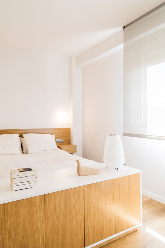 Diseño de dormitorio principal nórdico pequeño sin chimenea con paredes blancas y suelo de madera clara