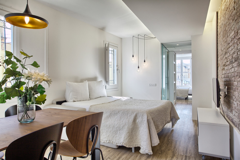 Modernes Schlafzimmer mit weißer Wandfarbe, dunklem Holzboden und braunem Boden in Madrid