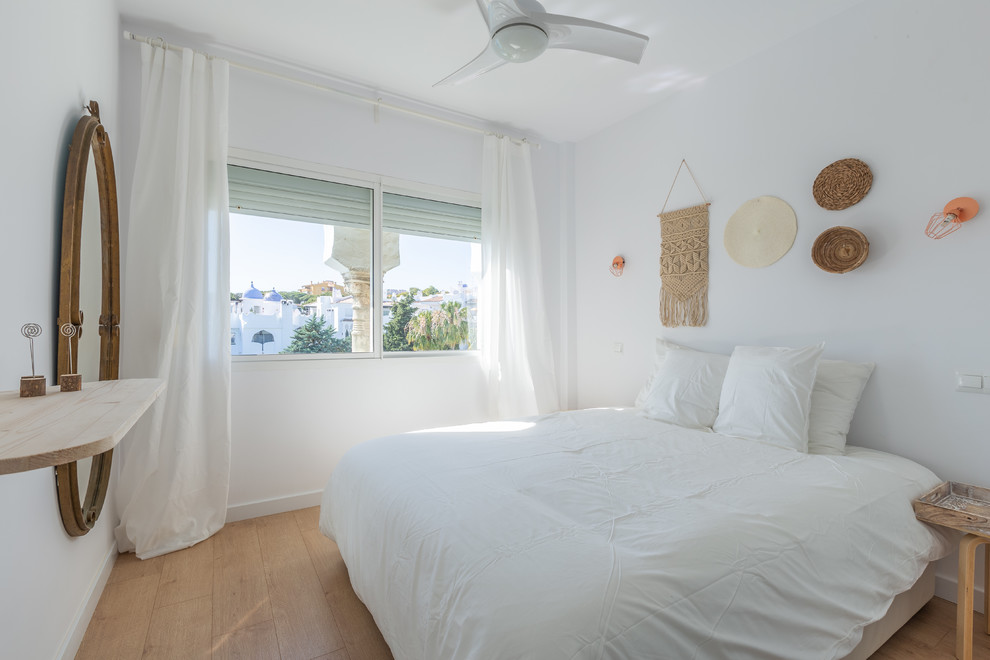 Exemple d'une chambre parentale méditerranéenne de taille moyenne avec un mur blanc, parquet clair et un sol marron.