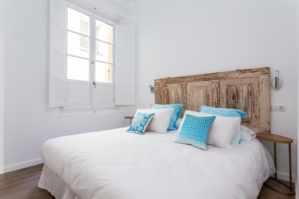 Imagen de dormitorio principal mediterráneo pequeño sin chimenea con paredes blancas y suelo de madera en tonos medios