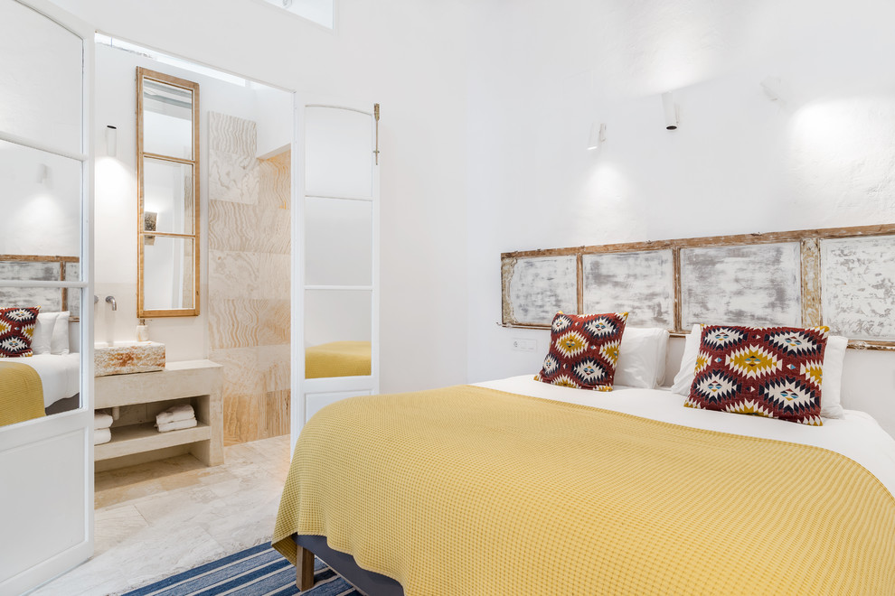 Modelo de dormitorio principal mediterráneo sin chimenea con paredes blancas y suelo beige