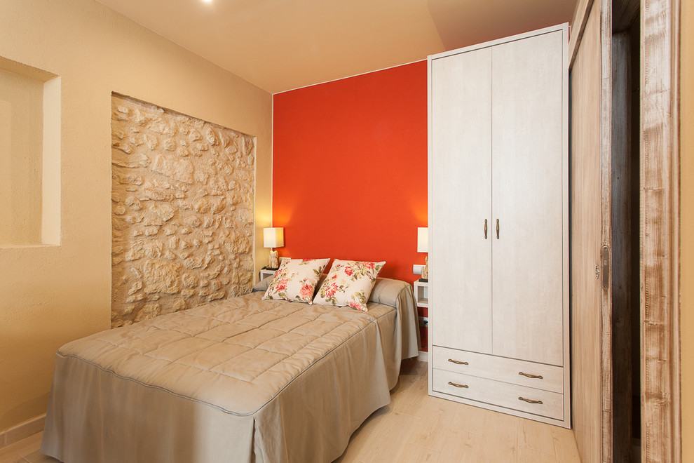 Imagen de habitación de invitados mediterránea pequeña sin chimenea con parades naranjas y suelo de madera clara