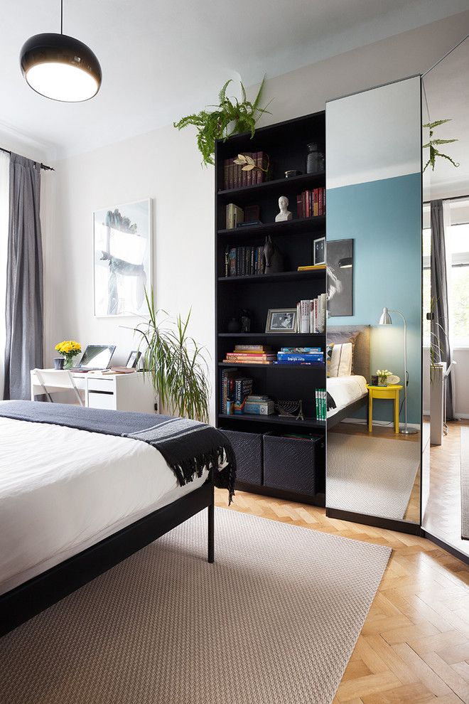 Small contemporary master bedroom in Other with beige walls and medium hardwood flooring.