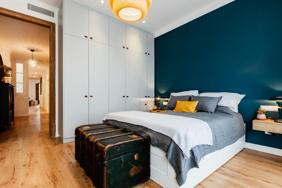 Foto di una camera da letto scandinava con pareti blu, parquet chiaro e pavimento beige