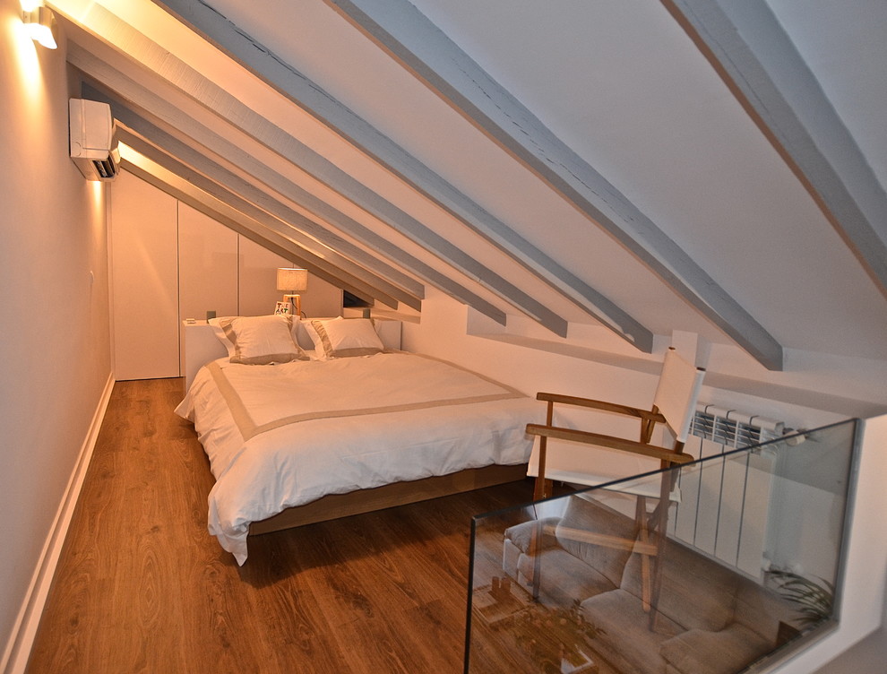 Foto di una camera da letto stile loft industriale di medie dimensioni con pareti bianche e pavimento in legno verniciato