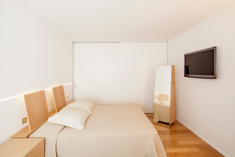 他の地域にある中くらいなコンテンポラリースタイルのおしゃれな主寝室 (白い壁、無垢フローリング、暖炉なし) のインテリア