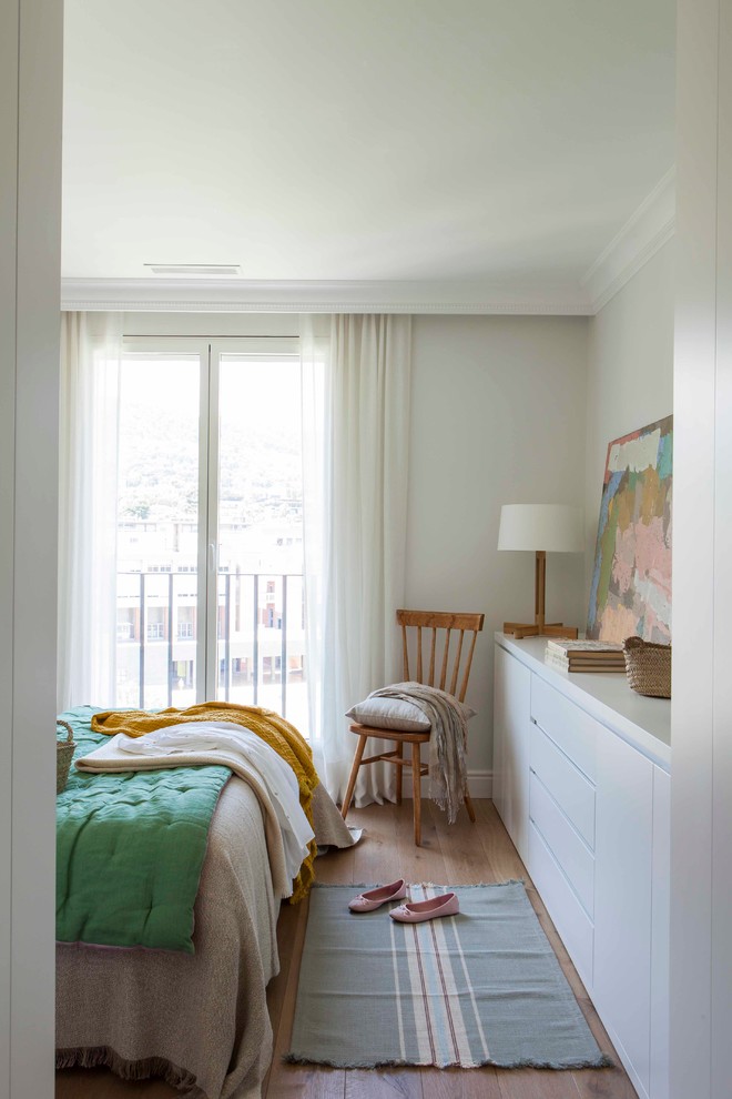 Foto de dormitorio principal nórdico de tamaño medio sin chimenea con suelo de madera en tonos medios