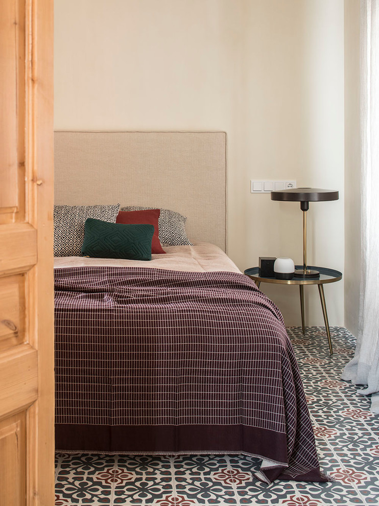 Immagine di una camera degli ospiti mediterranea di medie dimensioni con pareti beige, pavimento con piastrelle in ceramica e pavimento multicolore