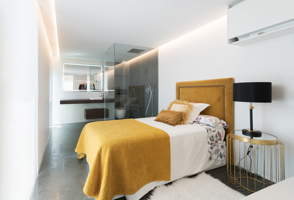 Imagen de dormitorio actual con paredes blancas, suelo de cemento y suelo gris