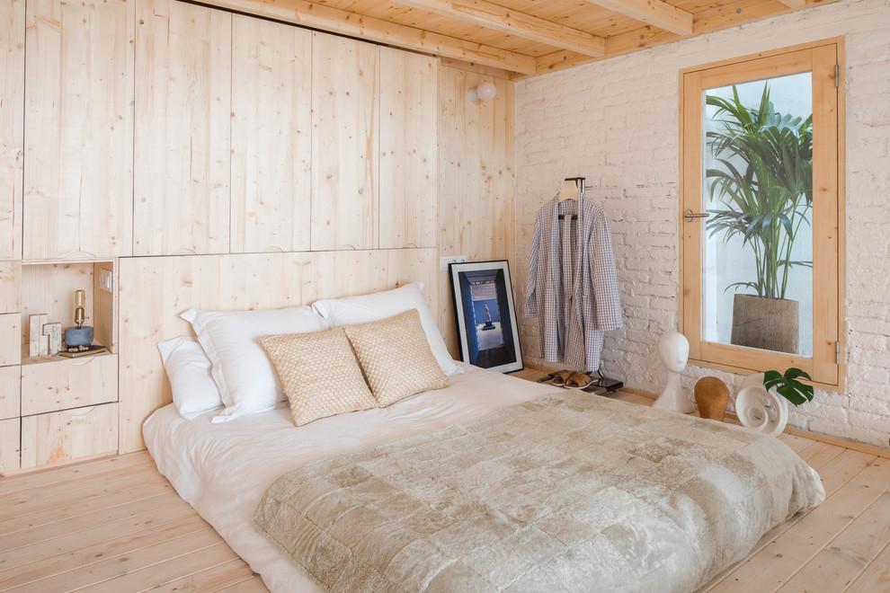 Imagen de dormitorio nórdico con paredes blancas, suelo de madera clara y suelo beige