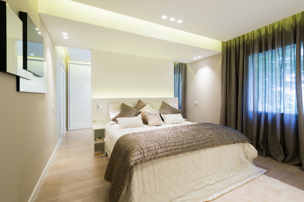 Mittelgroßes Modernes Hauptschlafzimmer ohne Kamin mit beiger Wandfarbe und hellem Holzboden in Barcelona