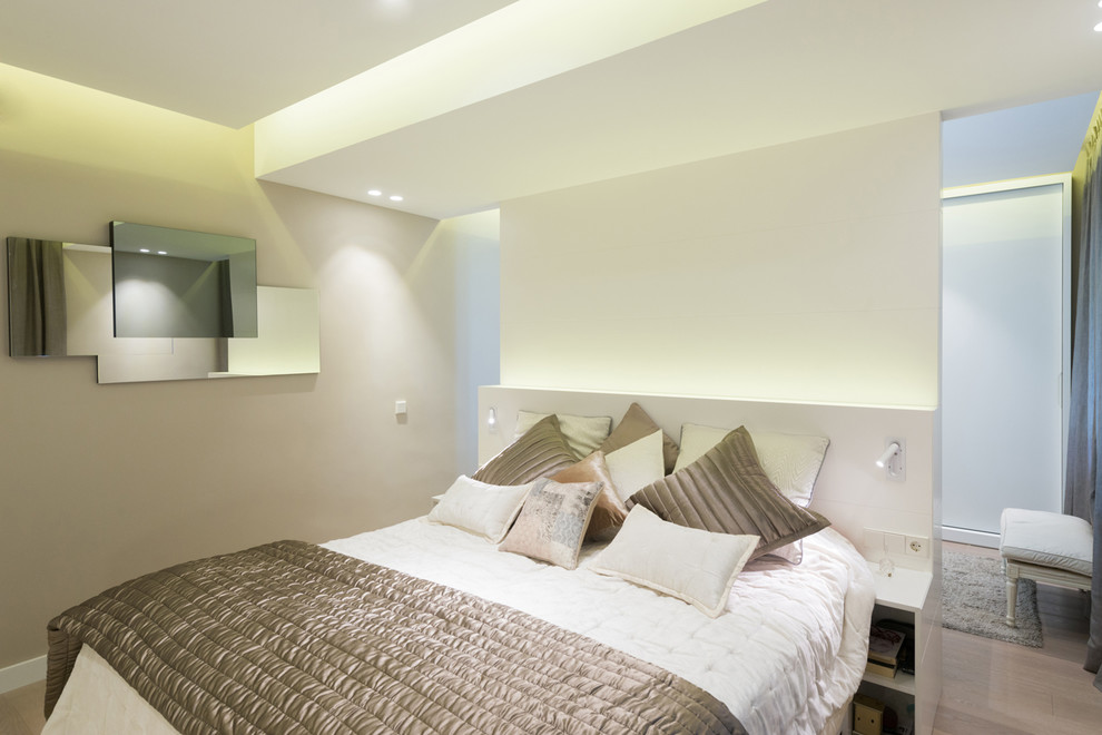 Diseño de dormitorio principal tradicional renovado de tamaño medio sin chimenea con paredes beige y suelo de madera clara