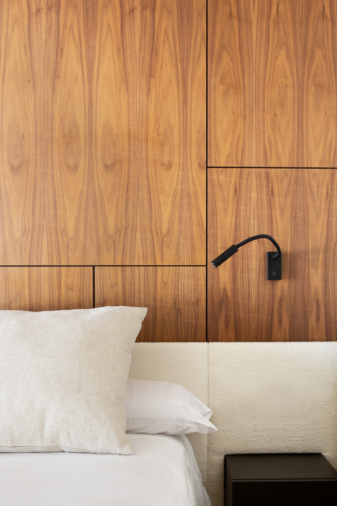 Ejemplo de dormitorio principal actual de tamaño medio con paredes marrones, suelo de madera en tonos medios y madera